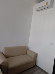 Living room with beige sofa and wall-mounted air conditioner