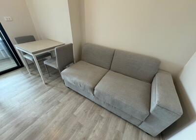 Modern living room with grey sofa and dining area