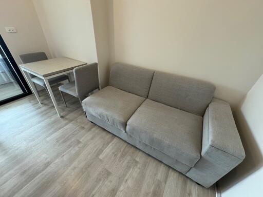 Modern living room with grey sofa and dining area