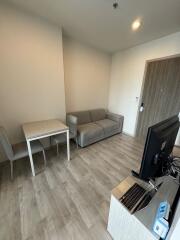 Modern living room with a sofa, table, and TV