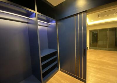 Walk-in closet with blue shelves and sliding door