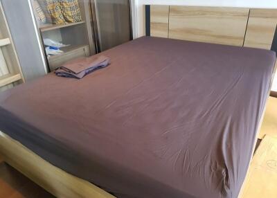 A well-organized bedroom with a neatly made bed and wooden elements.