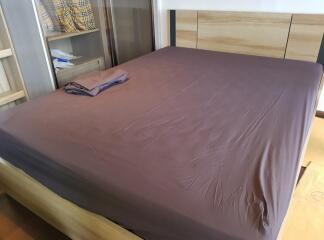 A well-organized bedroom with a neatly made bed and wooden elements.