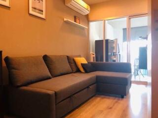 Modern living room with gray sectional sofa and air conditioner