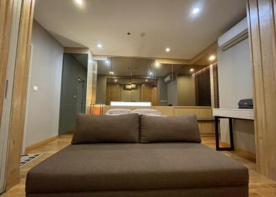 Spacious and modern living area with brown sofa and bright lighting