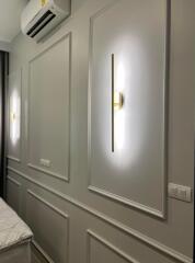 Wall with sconce lights and air conditioner in a bedroom