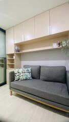 Living room with gray sofa and built-in wooden storage