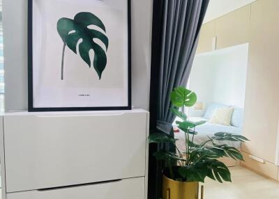 Bedroom with dresser, framed artwork, and potted plant next to sliding glass door