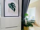 Bedroom with dresser, framed artwork, and potted plant next to sliding glass door