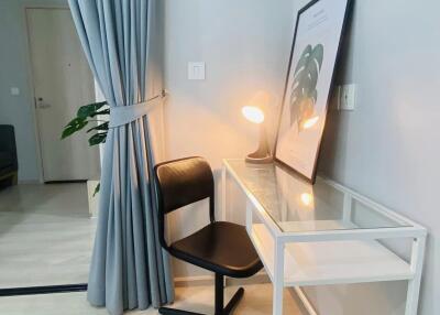 Minimalist bedroom corner with a desk, chair, and lamp