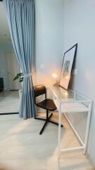 Minimalist bedroom corner with a desk, chair, and lamp