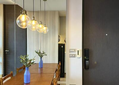 Modern dining area with wooden table and hanging light fixtures