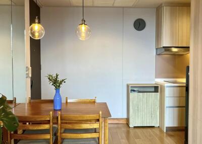 Modern kitchen dining area with wooden table and hanging lights