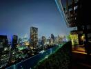 Stunning night cityscape view from a rooftop terrace with greenery and seating area