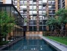 Outdoor view of a modern apartment complex with pool and greenery