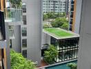 View of modern apartment buildings with a central courtyard including a pool and green space