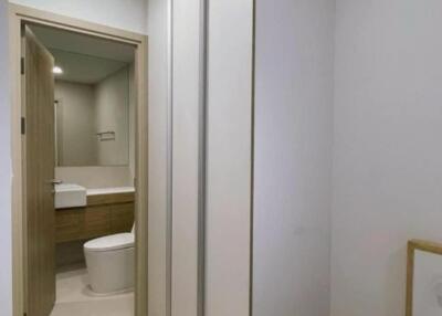 Hallway view with built-in cupboards and a bathroom