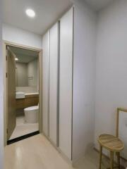 Hallway view with built-in cupboards and a bathroom