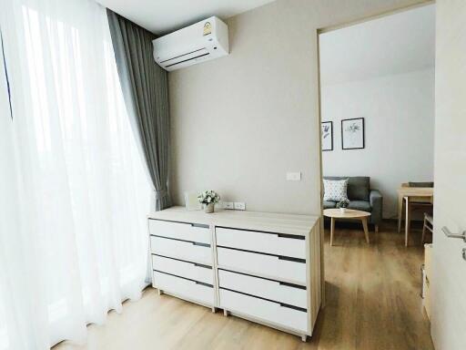 Well-lit bedroom with double chest of drawers and air conditioning