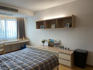 Cozy bedroom with a large window, desk, and storage shelf