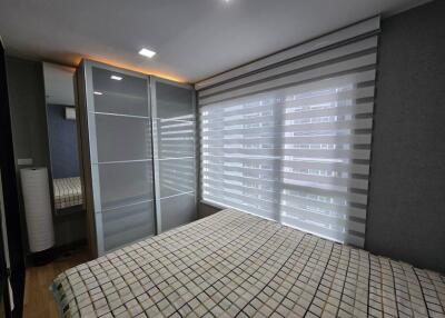 Modern bedroom with large window and striped blinds