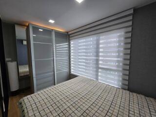 Modern bedroom with large window and striped blinds