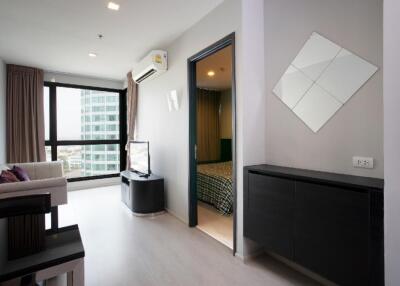 Modern living room with large window and view of adjacent bedroom