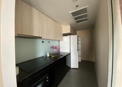 modern kitchen with black countertops and light wood cabinetry