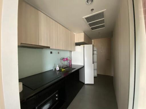 modern kitchen with black countertops and light wood cabinetry