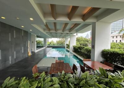 Outdoor pool and seating area with greenery