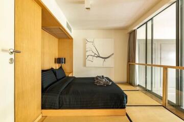 Modern bedroom with a large bed and sliding glass door to a balcony