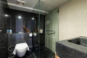 Modern bathroom with glass shower and dark countertops