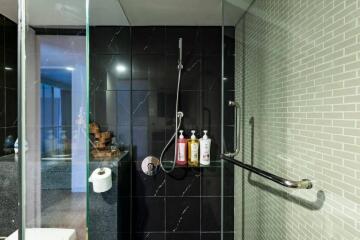 Modern bathroom with glass shower door and wall-mounted shower head