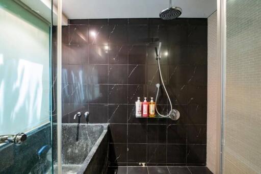 Modern bathroom with black tiled walls and fixtures