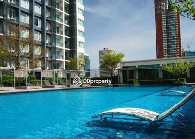 Outdoor swimming pool area with adjacent modern buildings