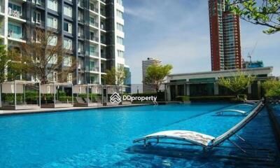 Outdoor swimming pool area with adjacent modern buildings