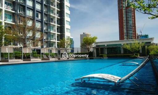 Outdoor swimming pool area with adjacent modern buildings