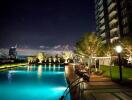 Night view of an outdoor pool area with adjacent modern building