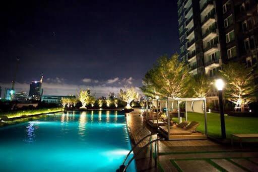 Night view of an outdoor pool area with adjacent modern building