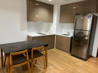 Modern kitchen with wooden dining table and stainless steel appliances