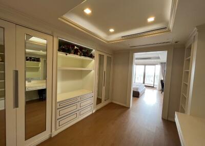 Bright bedroom with large mirrored wardrobes and built-in shelving