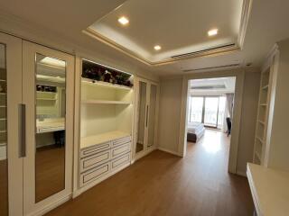 Bright bedroom with large mirrored wardrobes and built-in shelving