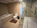 Modern bathroom with glass shower, bathtub, toilet, and marble countertop