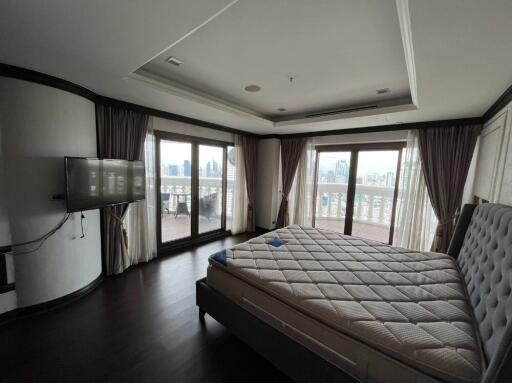 Spacious bedroom with large windows and city view