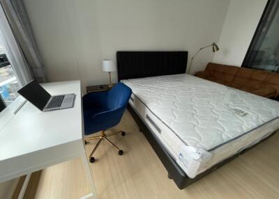 Bright bedroom with a laptop desk and chair, bed, and sofa