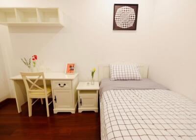 Bedroom with single bed, desk, and decorative wall art