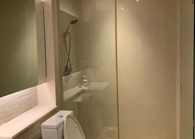 Modern bathroom with glass shower, toilet, and sink