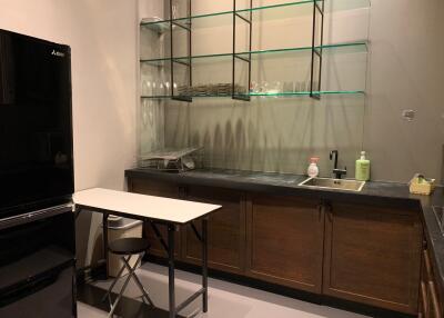 Modern kitchen with glass shelving and compact dining area