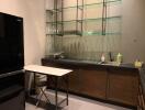 Modern kitchen with glass shelving and compact dining area