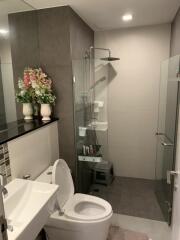 Modern bathroom with shower, toilet, sink, and decorative flowers